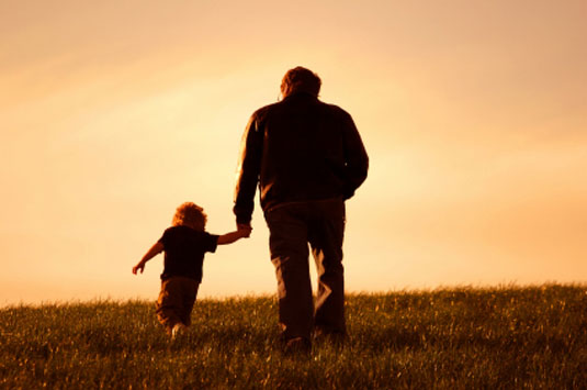 Father and child walk in the sunset